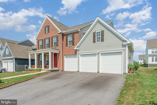 view of front of home featuring a front yard, an attached garage, brick siding, and driveway