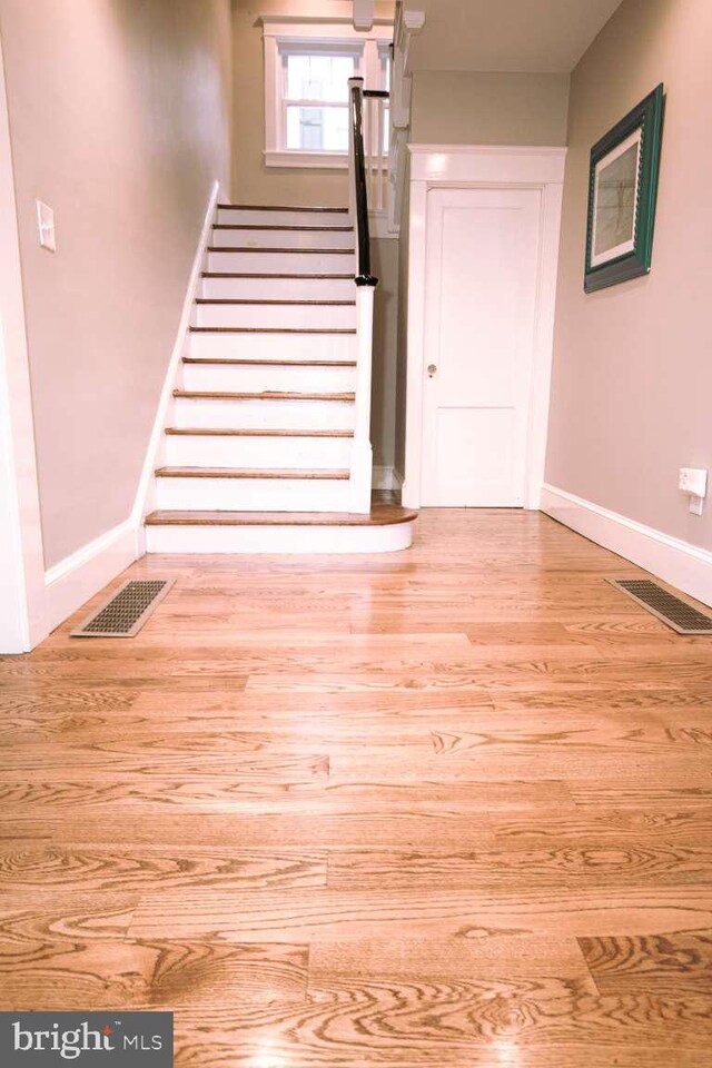 stairway with light hardwood / wood-style flooring