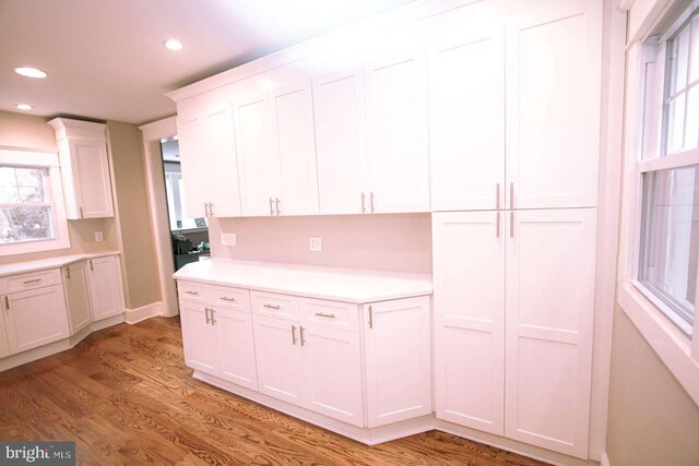 kitchen featuring white cabinetry, decorative backsplash, and light wood-type flooring