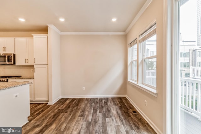 kitchen with ornamental molding, light stone countertops, white cabinets, and dark hardwood / wood-style flooring