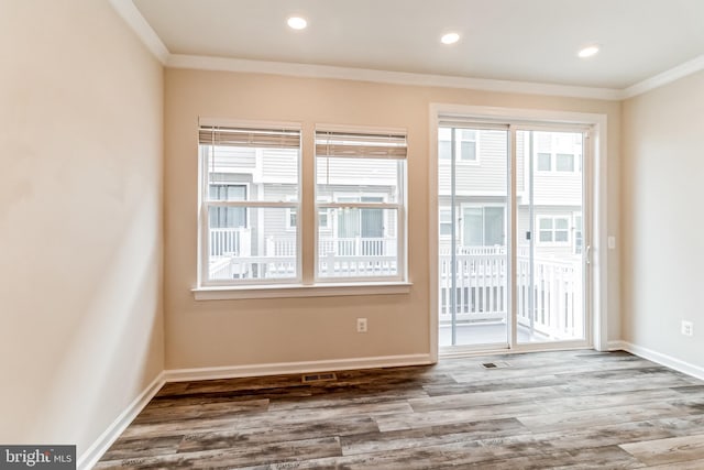 interior space with hardwood / wood-style floors, plenty of natural light, and ornamental molding