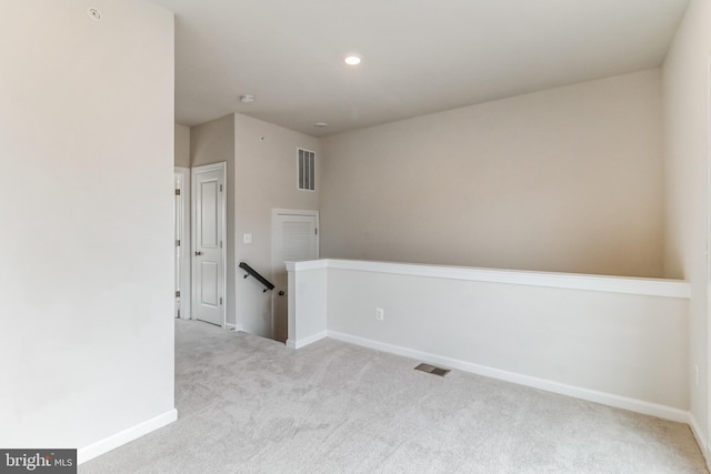 spare room featuring light colored carpet