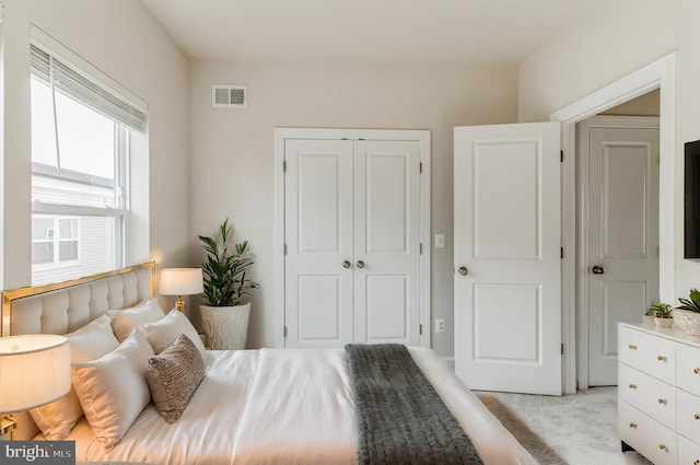 bedroom featuring light colored carpet and a closet