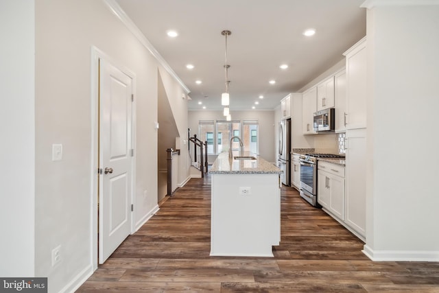 kitchen featuring white cabinetry, appliances with stainless steel finishes, a kitchen island with sink, and pendant lighting