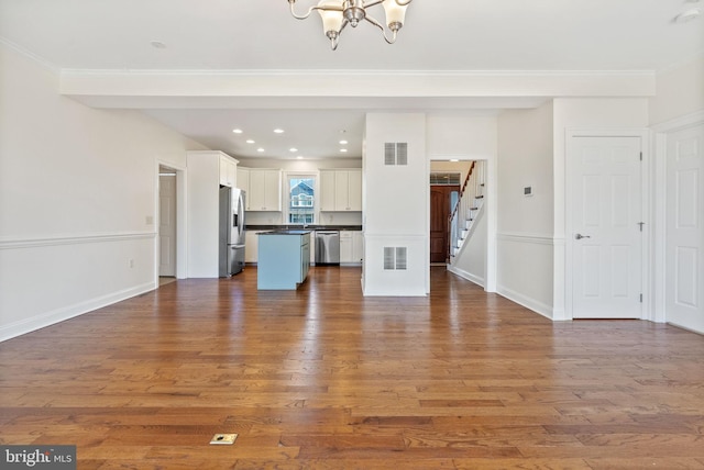 unfurnished living room with ornamental molding and wood-type flooring