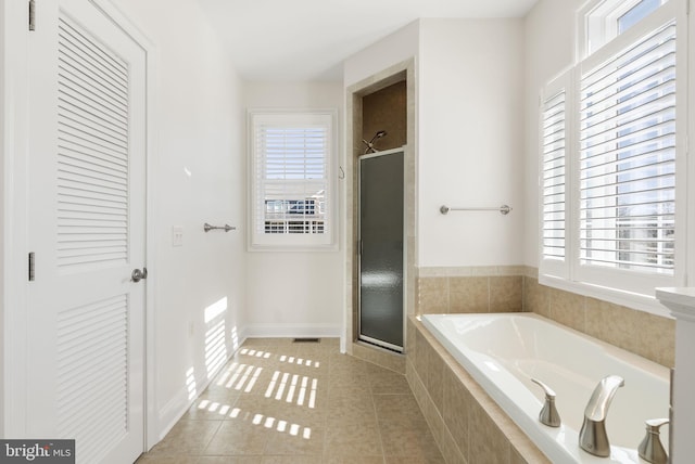 bathroom featuring a healthy amount of sunlight, independent shower and bath, and tile patterned floors