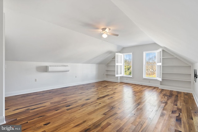 bonus room featuring vaulted ceiling, dark hardwood / wood-style floors, and built in features