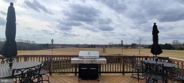 deck with a lawn and a rural view