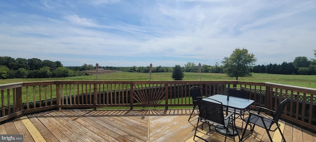 wooden terrace featuring a yard and a rural view