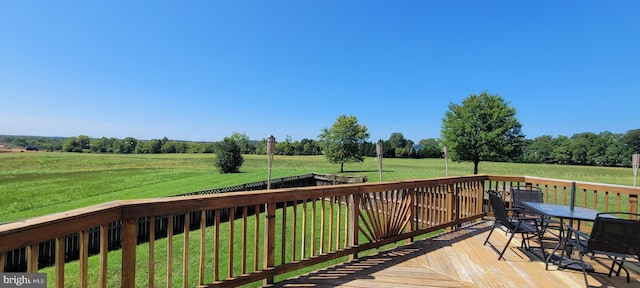 deck featuring a lawn and a rural view