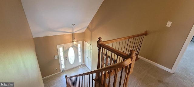 staircase featuring carpet and vaulted ceiling