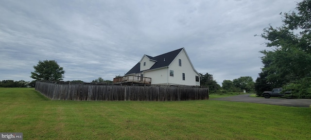 view of home's exterior featuring a deck and a lawn