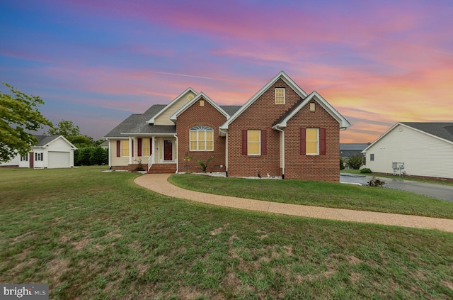 view of front of property with a garage, a lawn, and covered porch