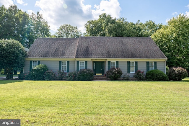 view of front of house with roof with shingles and a front lawn