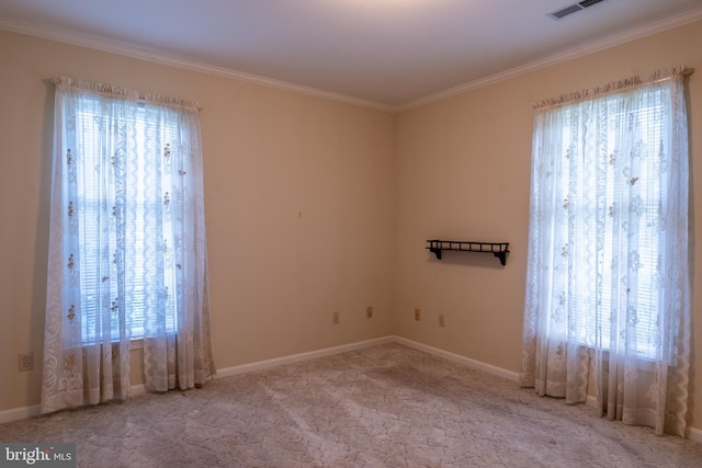 carpeted spare room featuring ornamental molding, visible vents, and baseboards