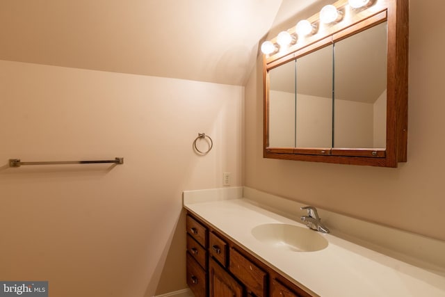 bathroom featuring vaulted ceiling and vanity