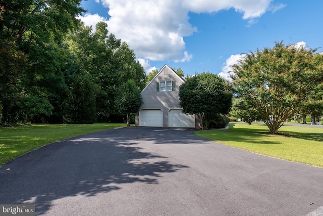 exterior space featuring an attached garage, aphalt driveway, and a front lawn