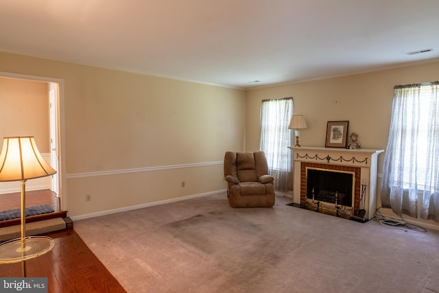 living area with crown molding, visible vents, a fireplace, and baseboards