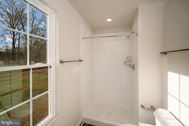 bathroom featuring toilet and tiled shower