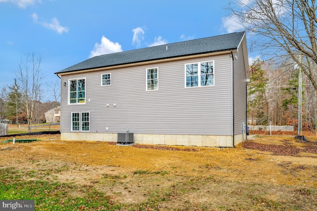 view of side of home with central AC and a lawn