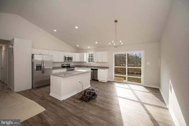 kitchen featuring white cabinetry, light stone counters, appliances with stainless steel finishes, a kitchen island, and pendant lighting