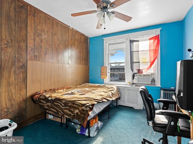 bedroom with radiator, wooden walls, ceiling fan, and dark colored carpet