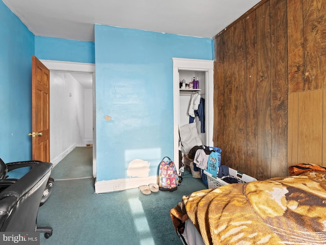 carpeted bedroom with wooden walls and a closet