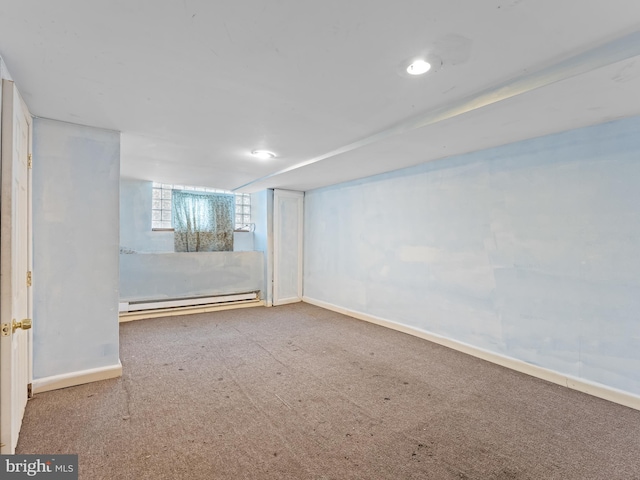 basement featuring carpet flooring and a baseboard heating unit