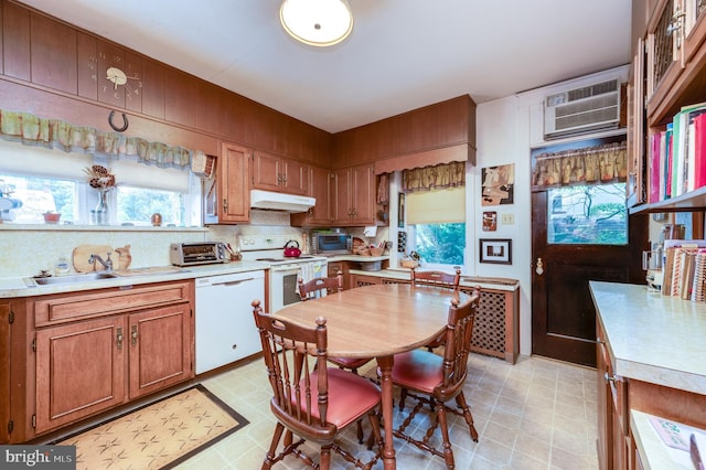 kitchen with white appliances, a wall mounted AC, and sink