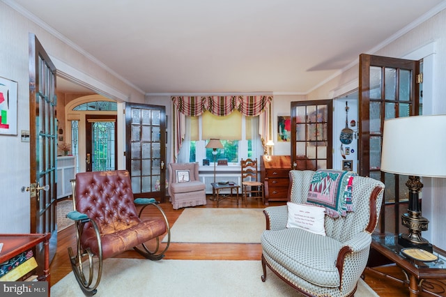 sitting room featuring crown molding, hardwood / wood-style floors, and french doors