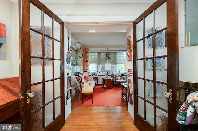 hall with light hardwood / wood-style floors and french doors