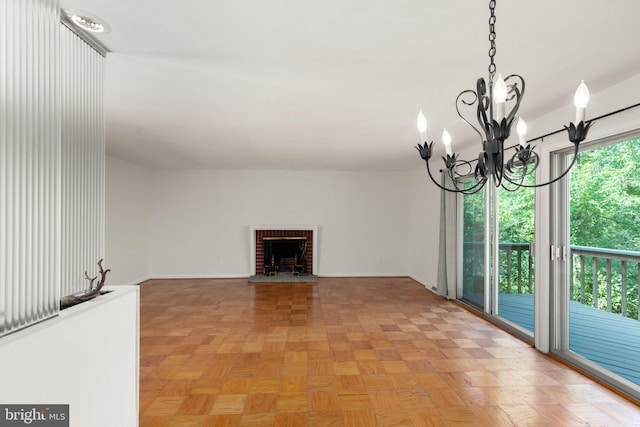 unfurnished living room featuring light parquet flooring, an inviting chandelier, and a fireplace