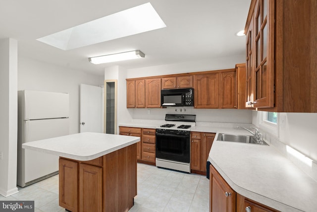 kitchen with sink, gas range, a skylight, a center island, and white refrigerator