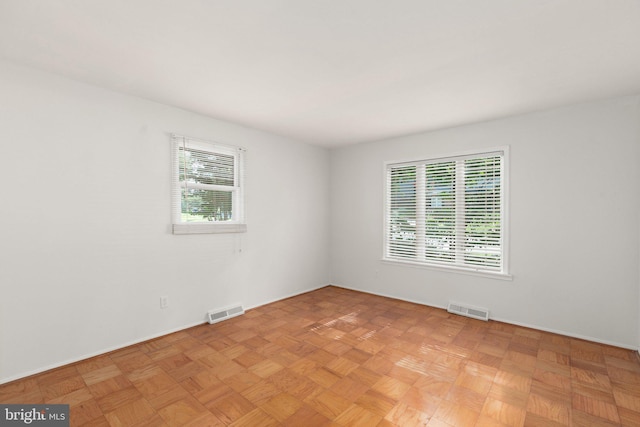 unfurnished room with light parquet floors and a wealth of natural light