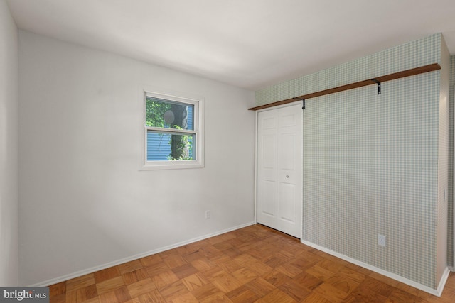 unfurnished bedroom featuring light parquet flooring and a closet