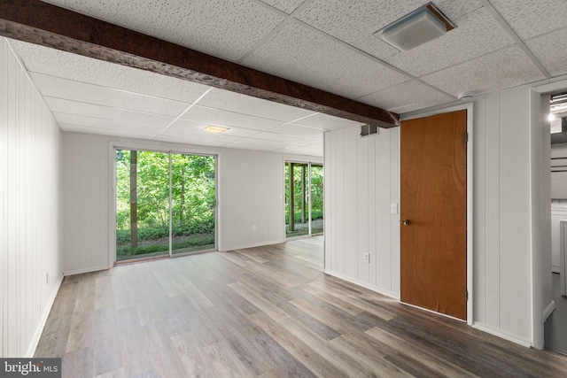 spare room featuring a drop ceiling and wood-type flooring