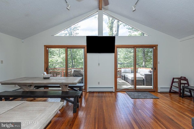 dining area featuring a baseboard heating unit, hardwood / wood-style floors, and a textured ceiling