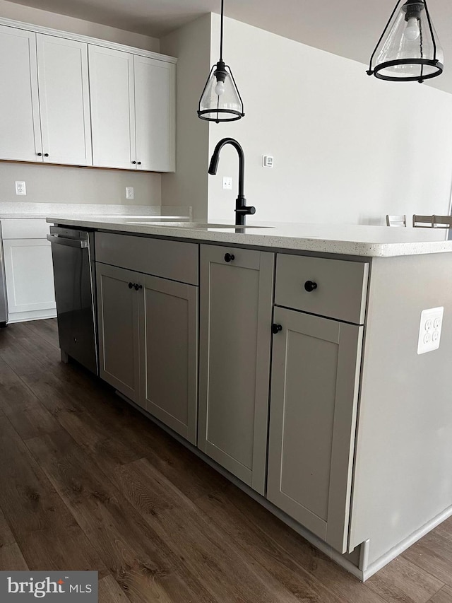 kitchen with dark hardwood / wood-style flooring, pendant lighting, sink, dishwashing machine, and gray cabinetry