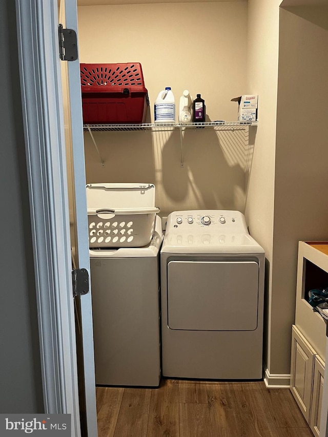 clothes washing area featuring hardwood / wood-style flooring and separate washer and dryer