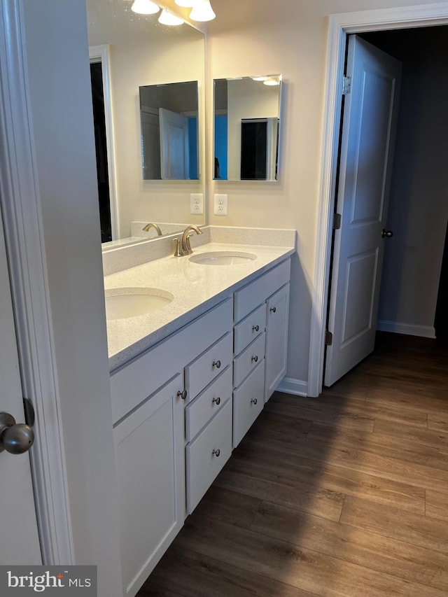 bathroom with double vanity and hardwood / wood-style flooring