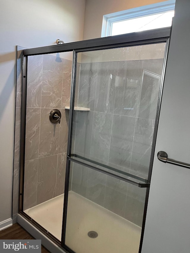 bathroom featuring a shower with shower door and hardwood / wood-style floors