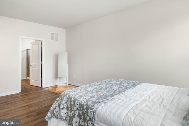 bedroom with dark hardwood / wood-style flooring