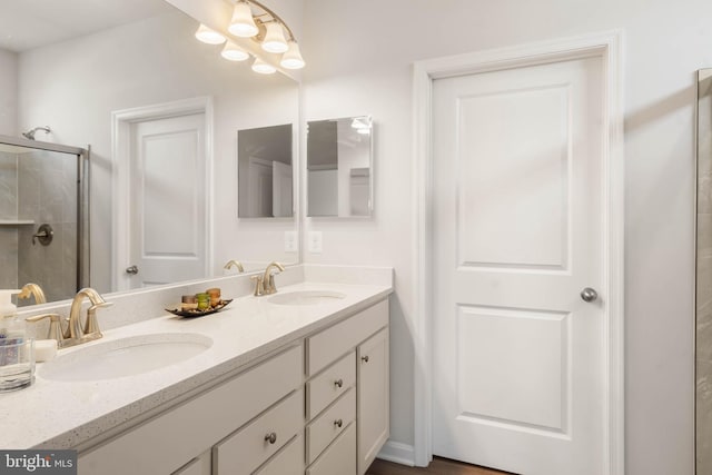 bathroom featuring double vanity and an enclosed shower