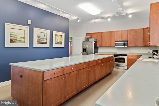 kitchen with track lighting, sink, stainless steel appliances, and a kitchen island