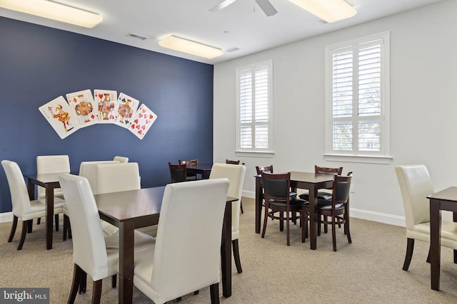 dining area with ceiling fan, light colored carpet, and plenty of natural light