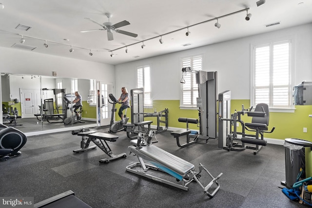 exercise room featuring ceiling fan, track lighting, and a healthy amount of sunlight