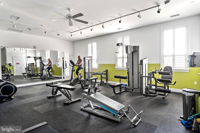 workout area with ceiling fan, a wealth of natural light, and track lighting