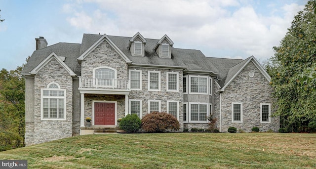 view of front facade featuring a front yard and a balcony