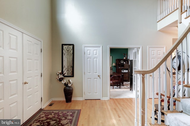 foyer entrance with hardwood / wood-style floors and a high ceiling