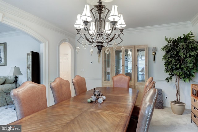 dining area featuring light carpet, crown molding, and a chandelier